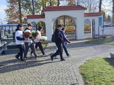 Młodzież z Kamionki pomaga odwiedzającym cmentarz parafialny