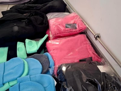 Odzież z podrobionymi znakami towarowymi w rękach policjantów