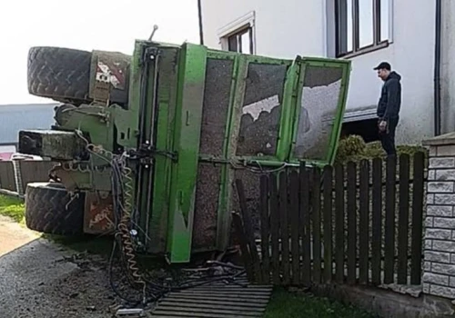 Traktor z przyczepą kukurydzy przewrócił się pod domem. Ładunek zasypał posesję