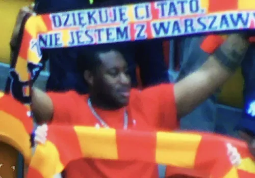 Czarnoskóry mężczyzna z szalikiem 'dziękuję ci tato, że nie jestem z Warszawy'