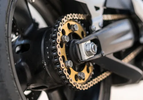 Jakie objawy luźnego łańcucha w motocyklu sygnalizują konieczność natychmiastowej regulacji napędu?