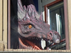 Ruchomy smok w oknie w Krakowie. Obserwuje z góry mieszkańców